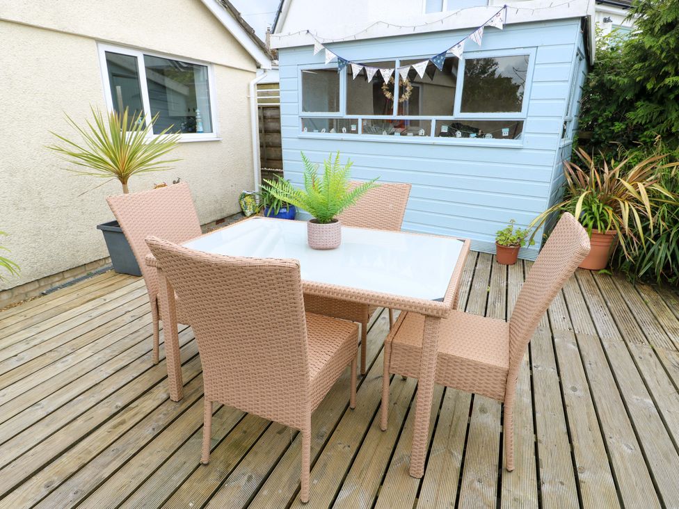 A garden with a table and chairs at Sea View in Benllech