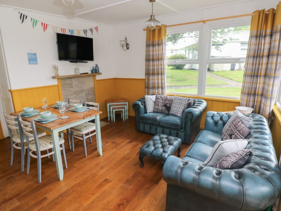 A living room with a sofa and dining area at Driftwood in Roch