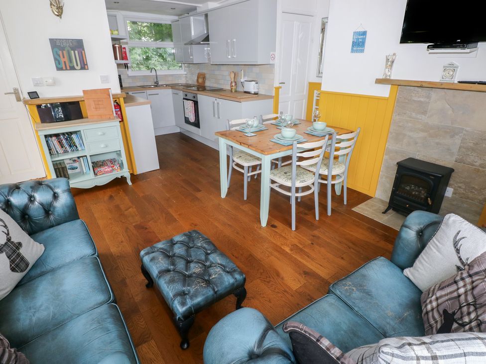 A living room with a dining area and kitchen at Driftwood in Roch