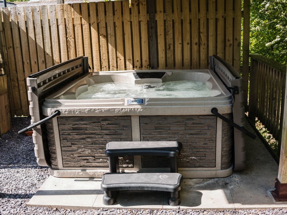 A hot tub with steps on a gravel area at Reflection in Longtown