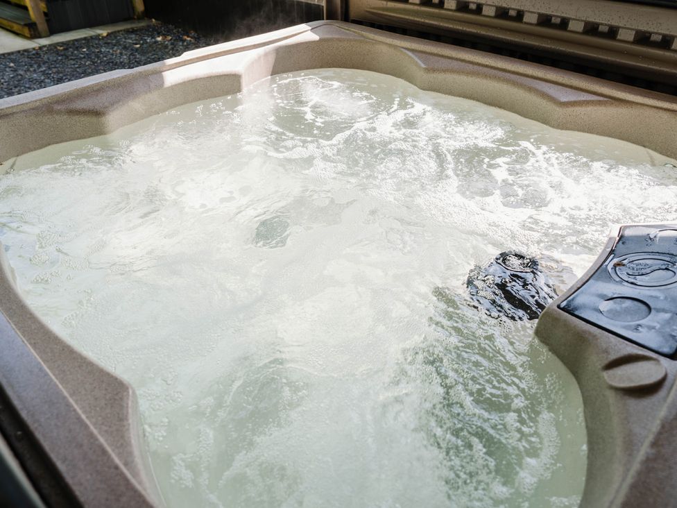 A hot tub filled with water in an outdoor area at Reflection in Longtown