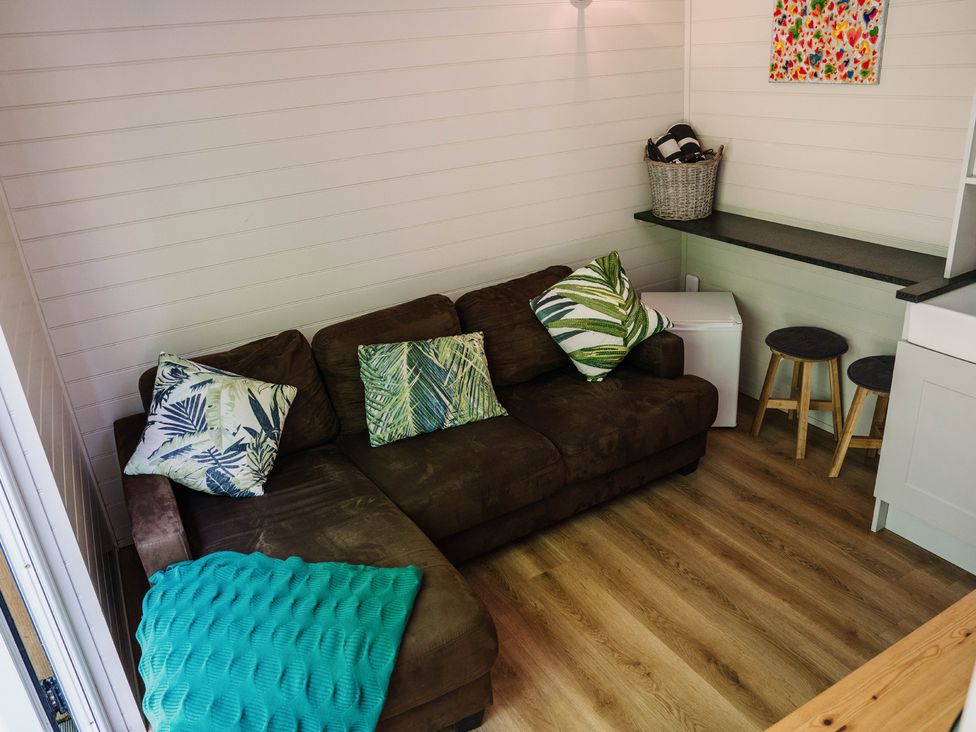 A living room with a brown sofa and a table at Reflection in Longtown