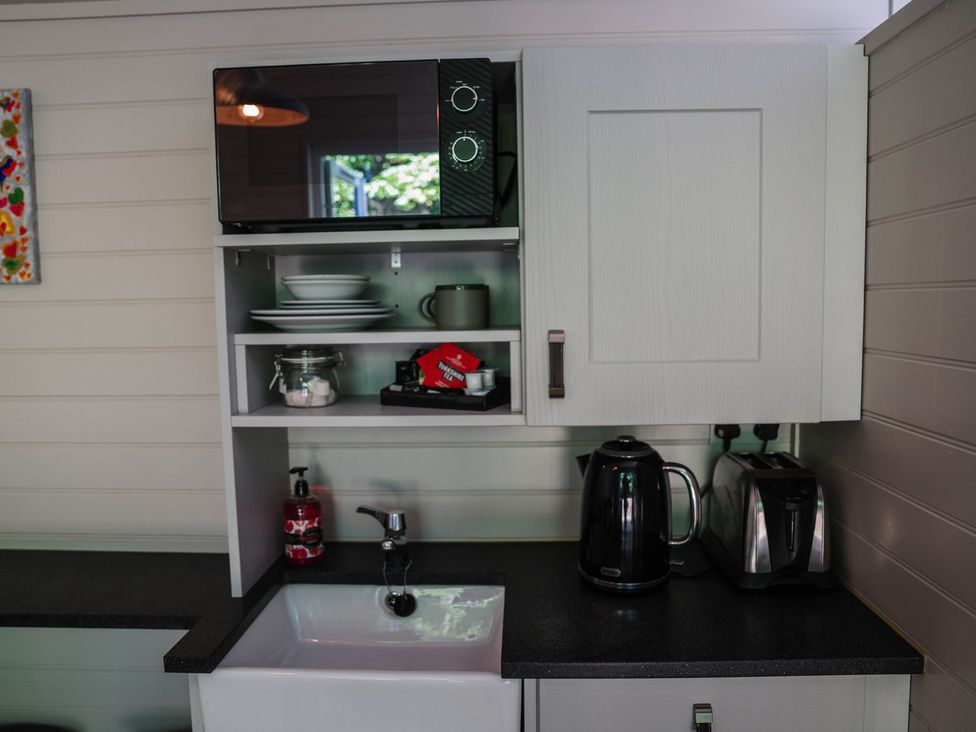 A kitchen with a microwave, kettle, and sink at Reflection in Longtown