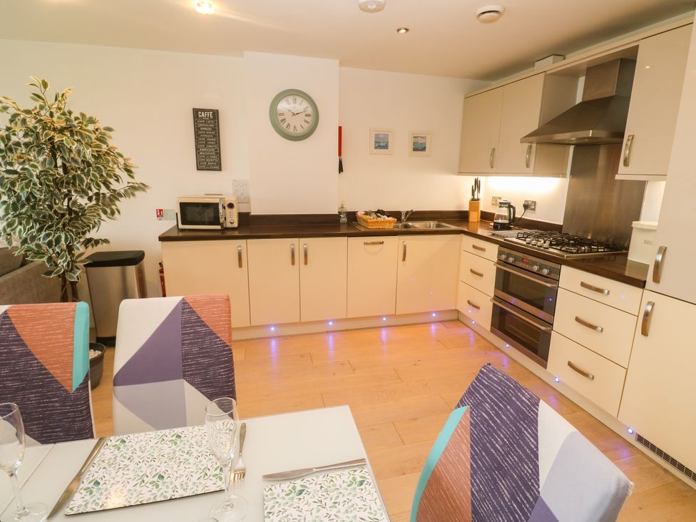 A kitchen with a microwave, sink, and stove at Ocean Seven in Newquay