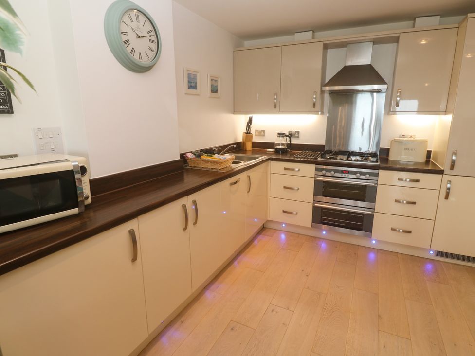 A kitchen with cabinets and appliances at Ocean Seven in Newquay