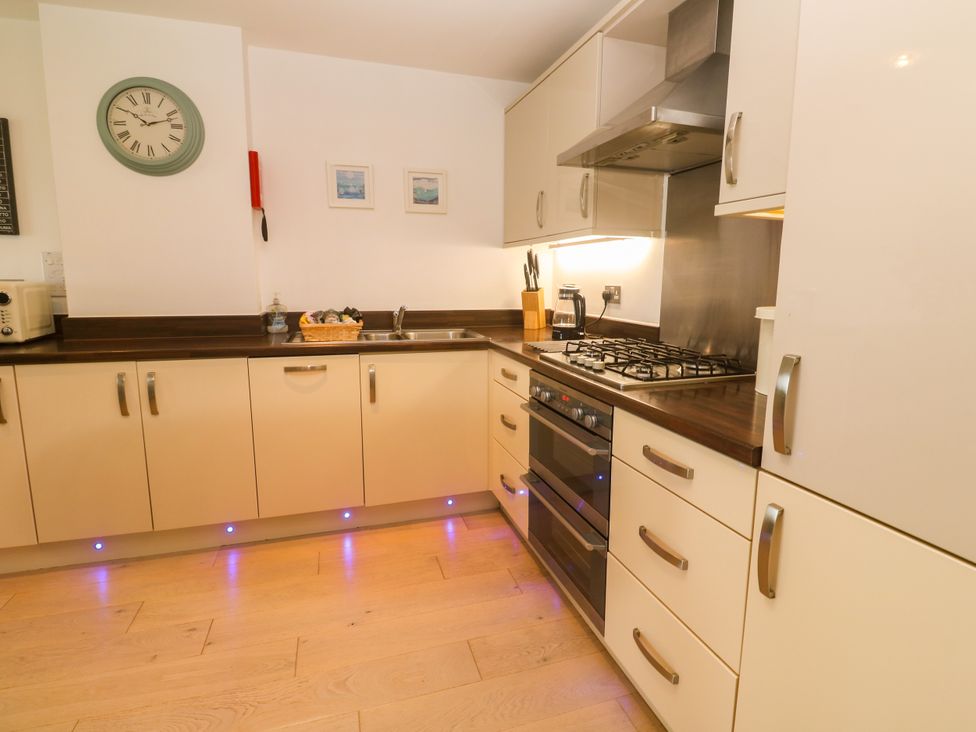 A kitchen with appliances and cabinets at Ocean Seven in Newquay