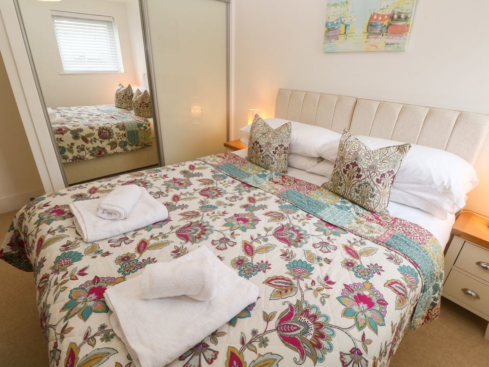 A bedroom with bed and mirror at Ocean Seven in Newquay