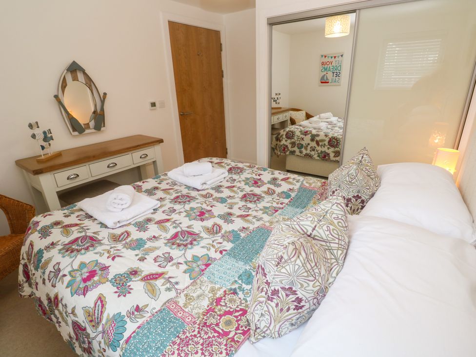 A bedroom with a bed and a mirror at Ocean Seven in Newquay