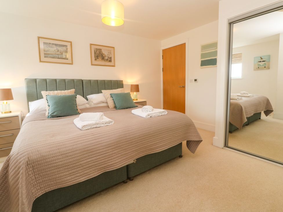 A bedroom with two beds and nightstands at Ocean Seven in Newquay