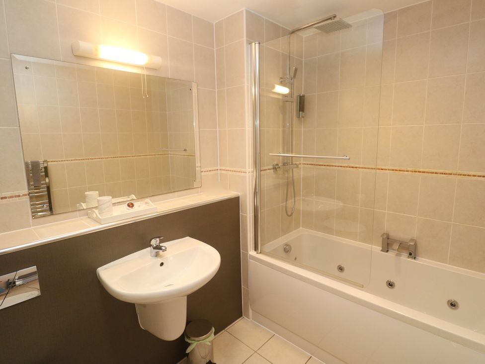 A bathroom with a sink, bath tub and shower at Ocean Seven in Newquay