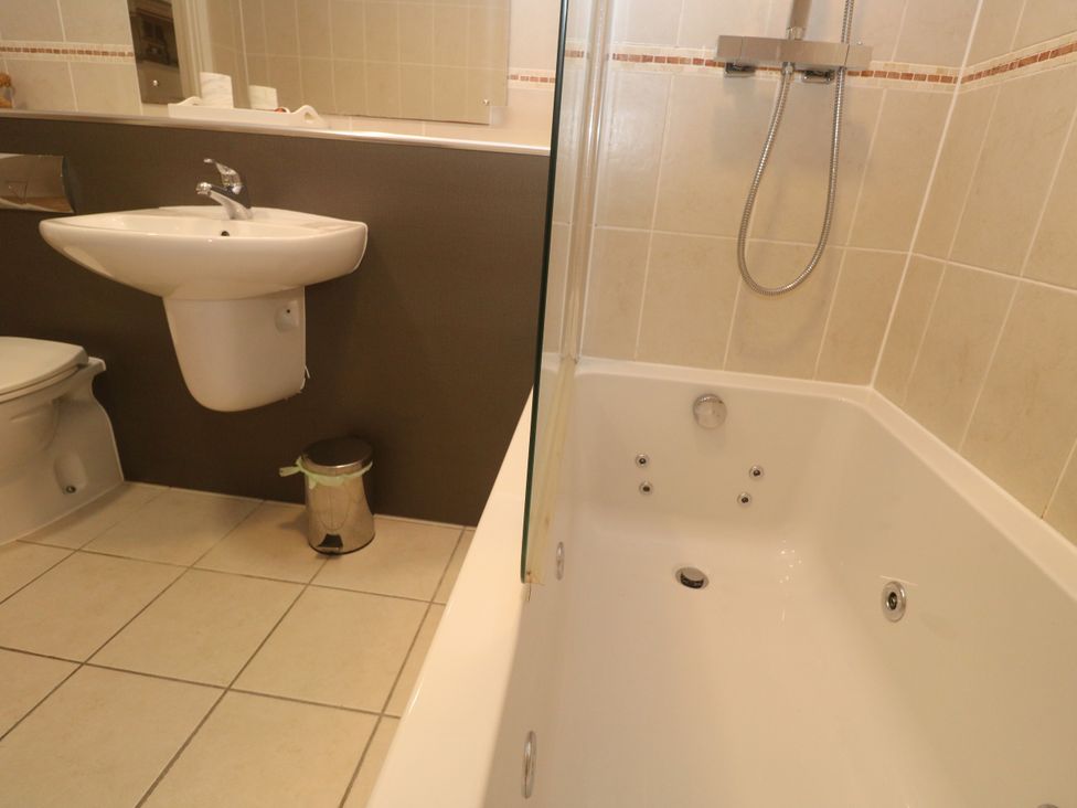 A bathroom with a bathtub, toilet, and sink at Ocean Seven in Newquay