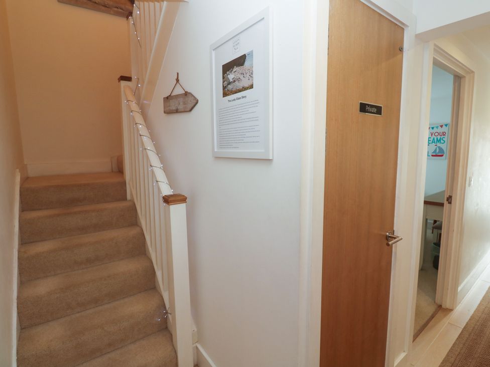 A hallway with stairs and a door labeled Private at Ocean Seven in Newquay