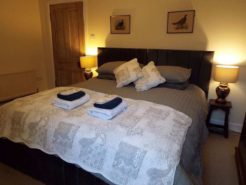 A bedroom with a bed and bedside lamps at Milltown House, Turriff