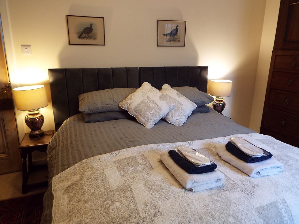A bedroom with a bed and bedside lamps at Milltown House in Turriff