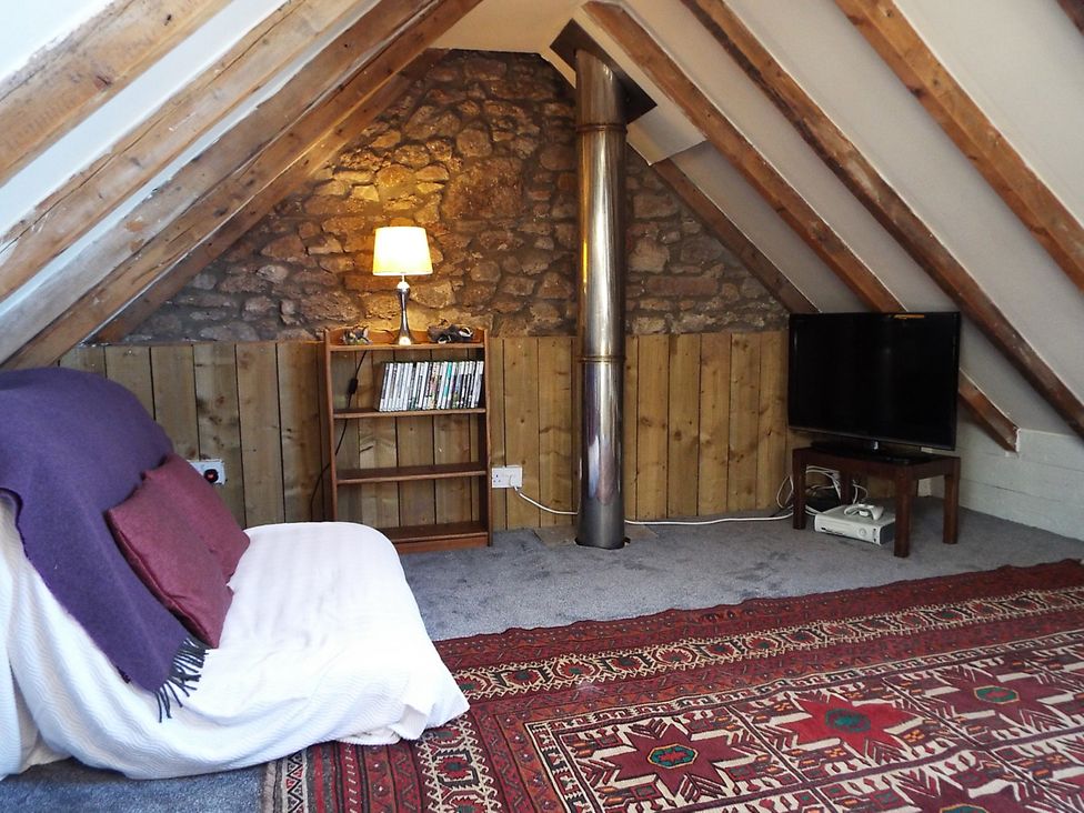 A living room with a sofa and television at Milltown House in Turriff