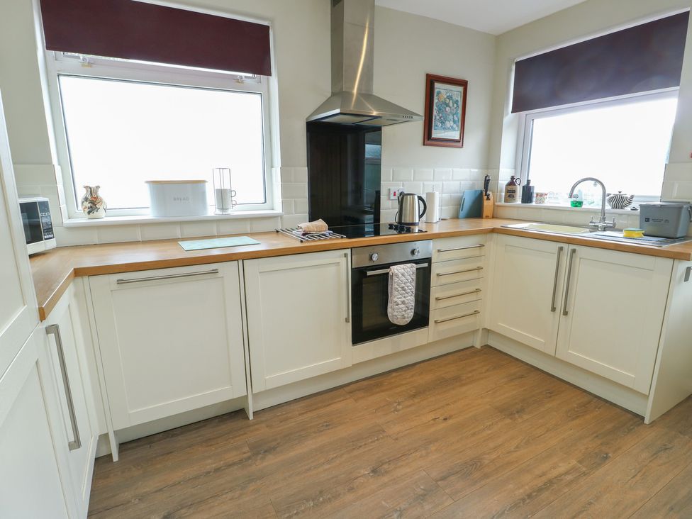 A kitchen with cabinets and appliances at Awelon in Rhos-On-Sea