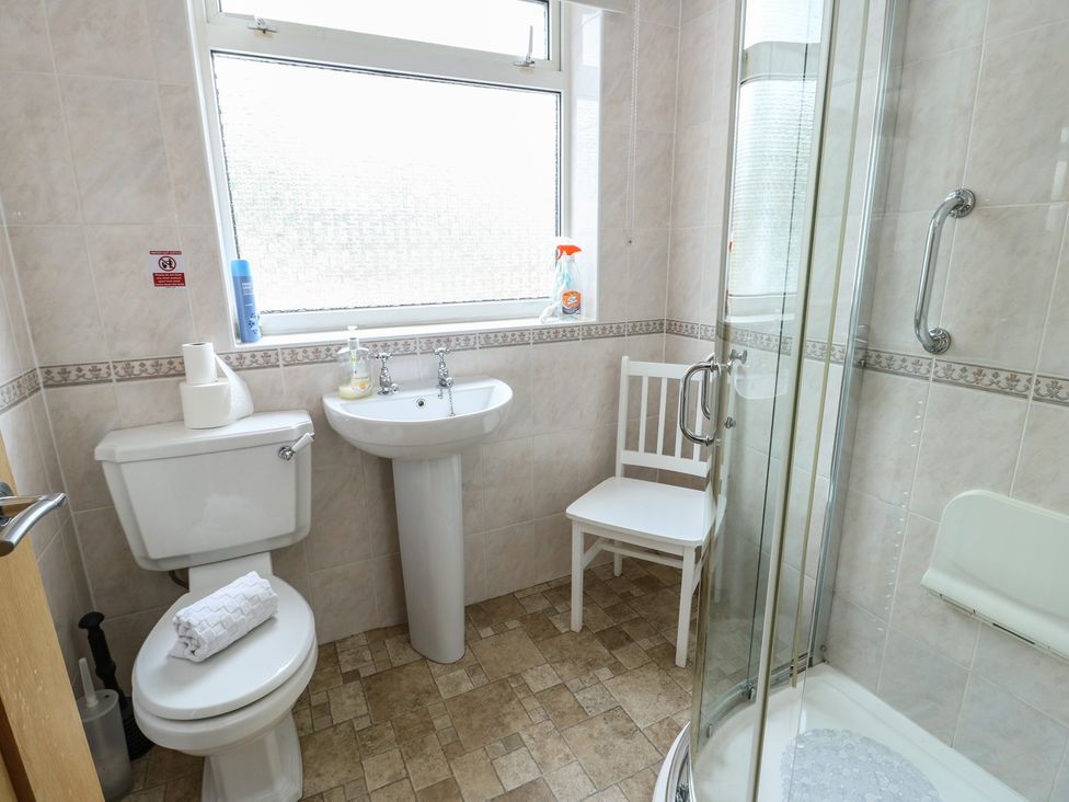 A bathroom with a shower and sink at Awelon in Rhos-On-Sea