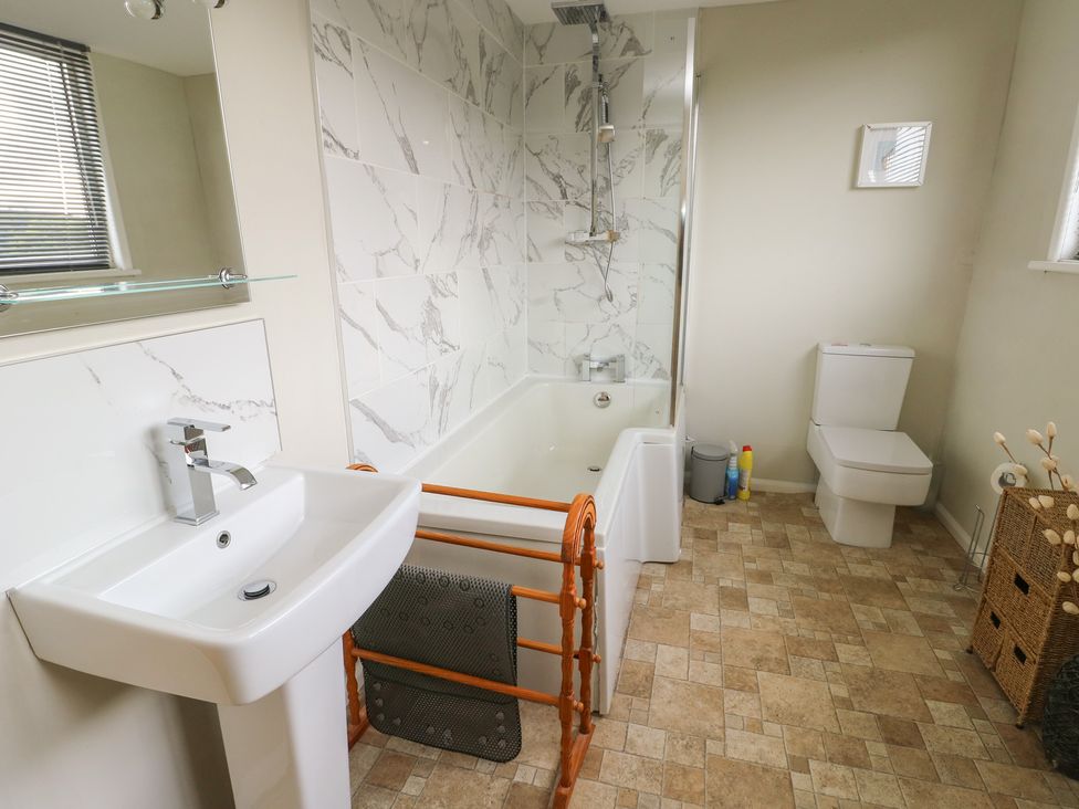 A bathroom with a sink, bathtub, toilet and shower at Awelon Rhos-On-Sea