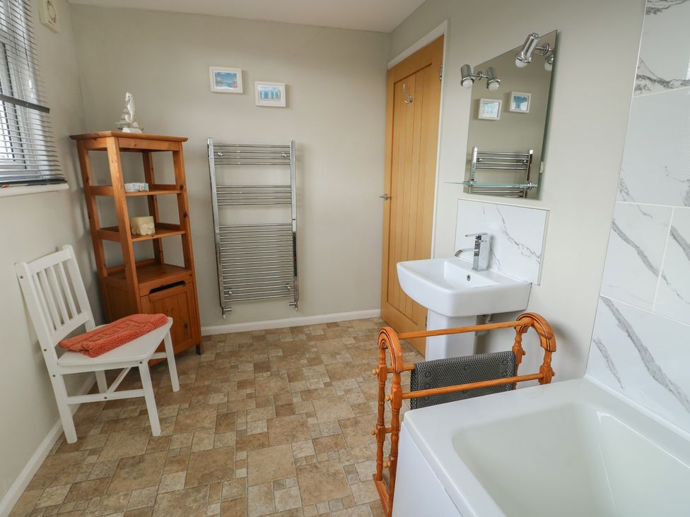 A bathroom with a sink and bath tub at Awelon in Rhos-On-Sea