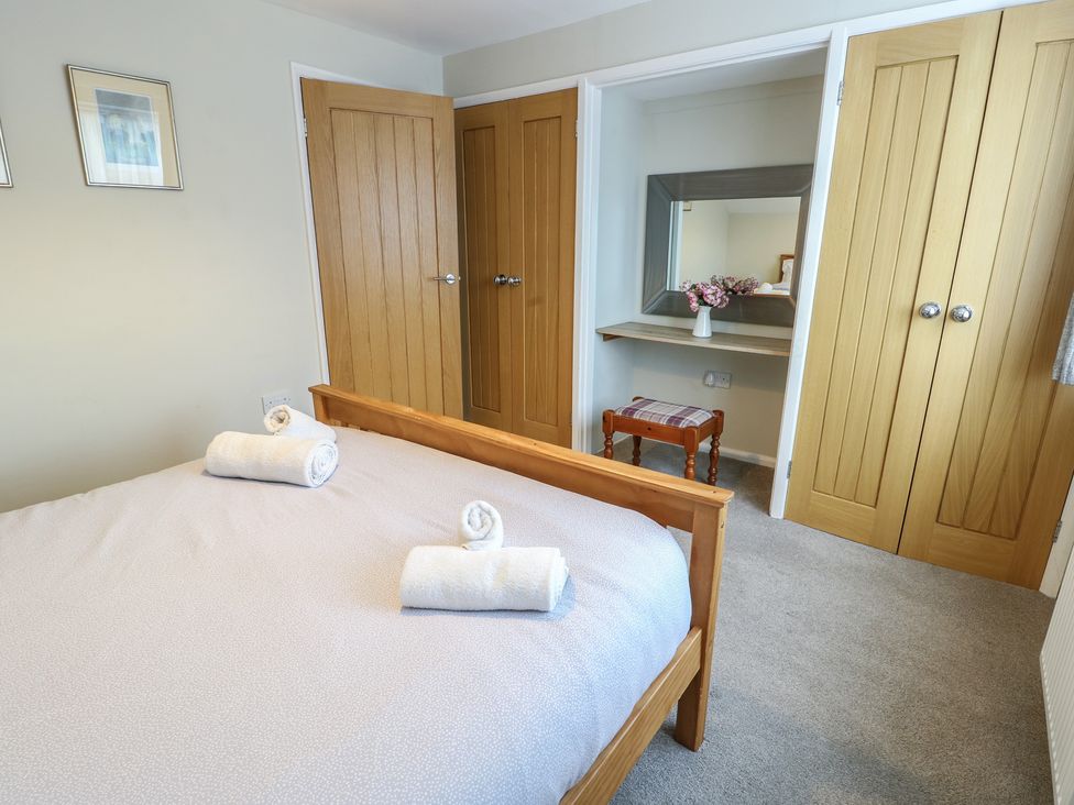 A bedroom with a bed and towels on it at Awelon in Rhos-On-Sea