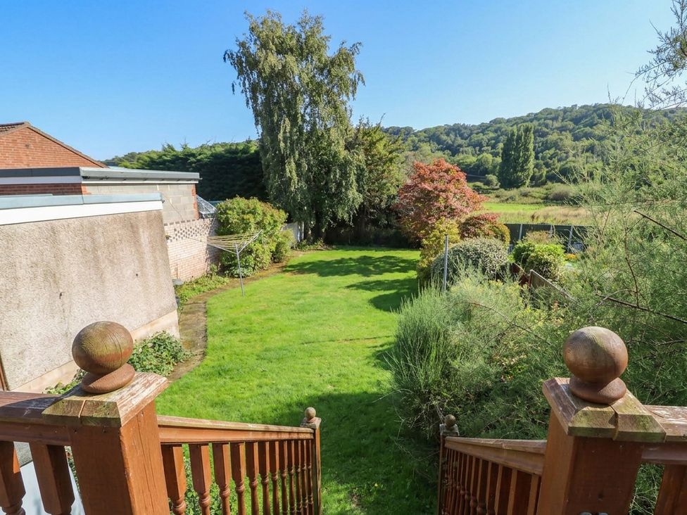 A garden with grass and trees at Awelon in Rhos-On-Sea
