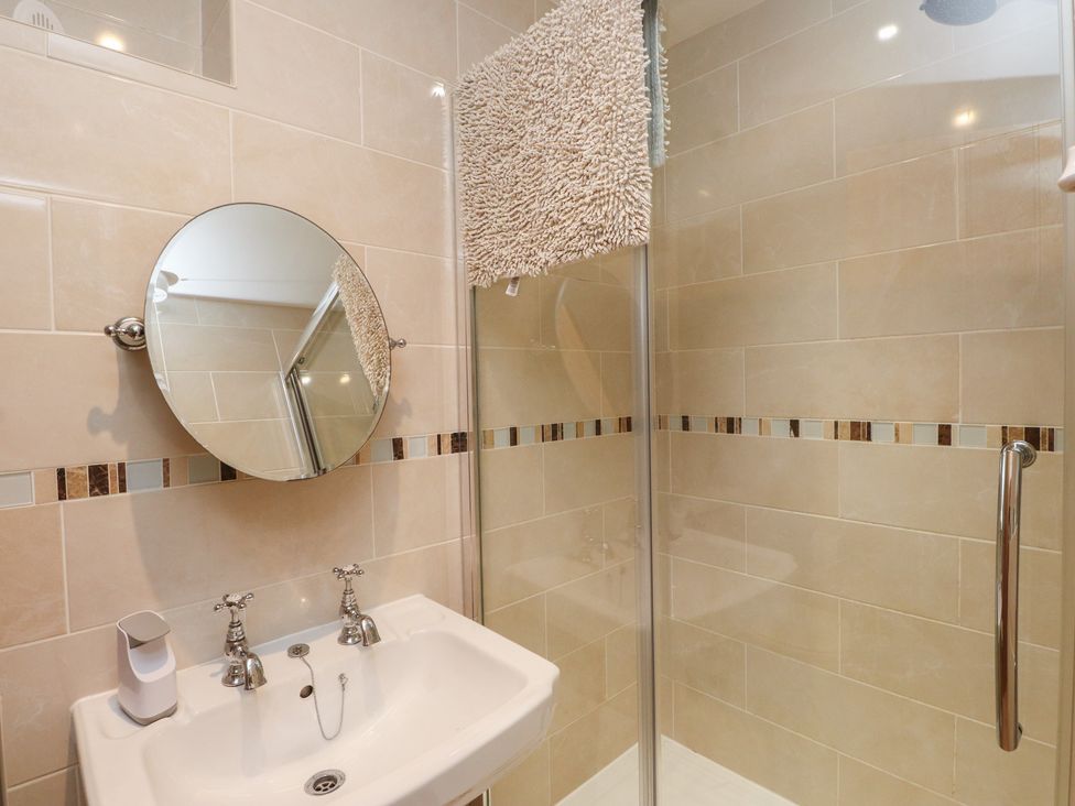 A bathroom with a sink and shower at Plas Mawr in Groeslon
