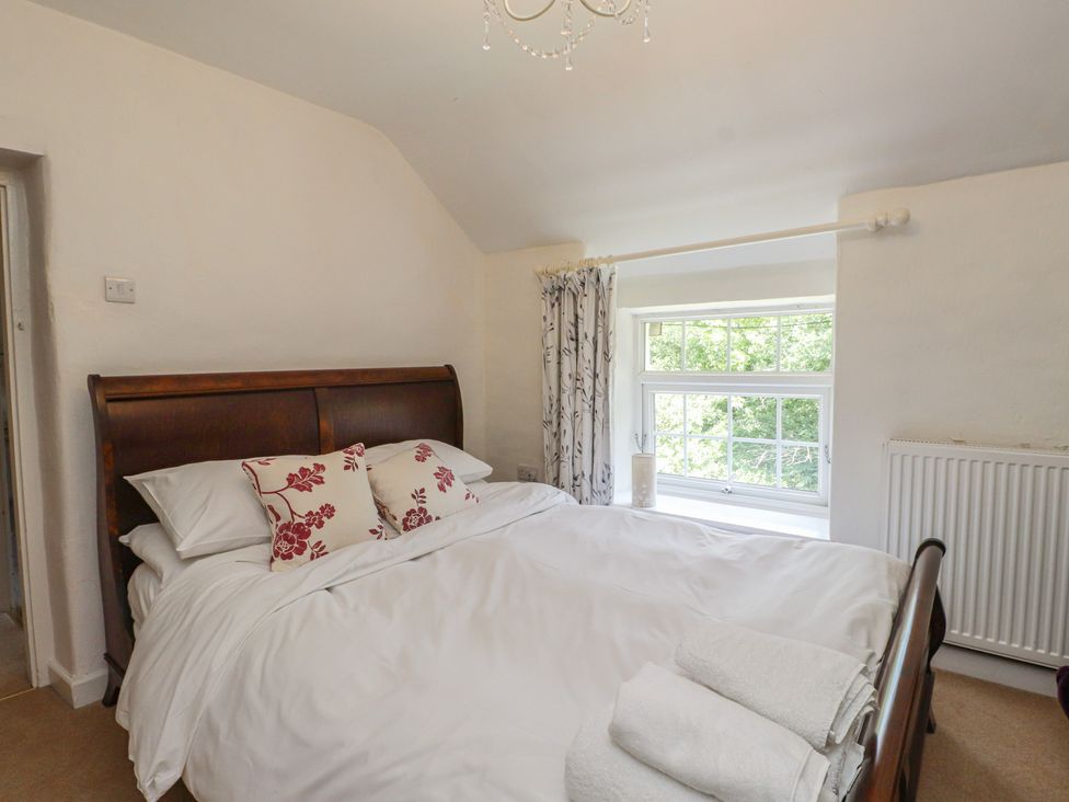 A bedroom with a bed and window at Plas Mawr in Groeslon