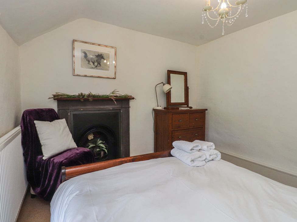 A bedroom with a bed and furniture at Plas Mawr in Groeslon