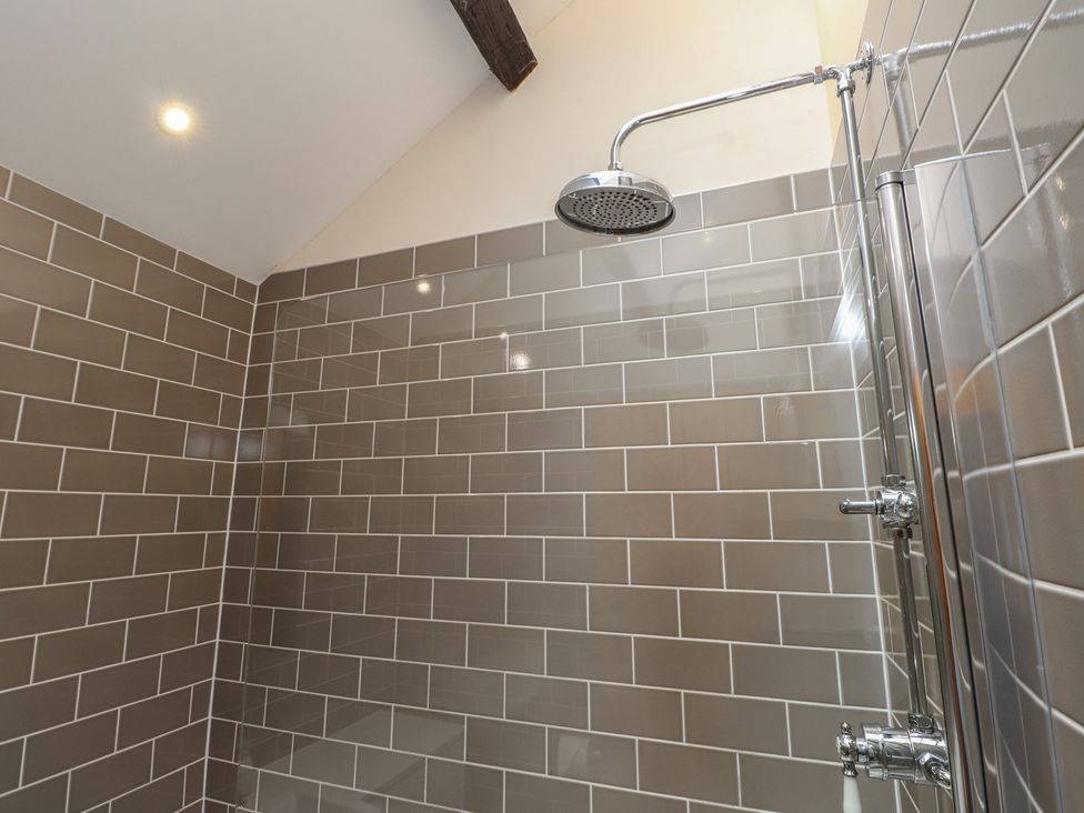 A shower with tiles and fixtures at Beudy'r Wennol in Groeslon