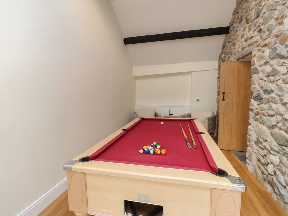 A pool table with cues in a snug at Beudy'r Wennol Groeslon