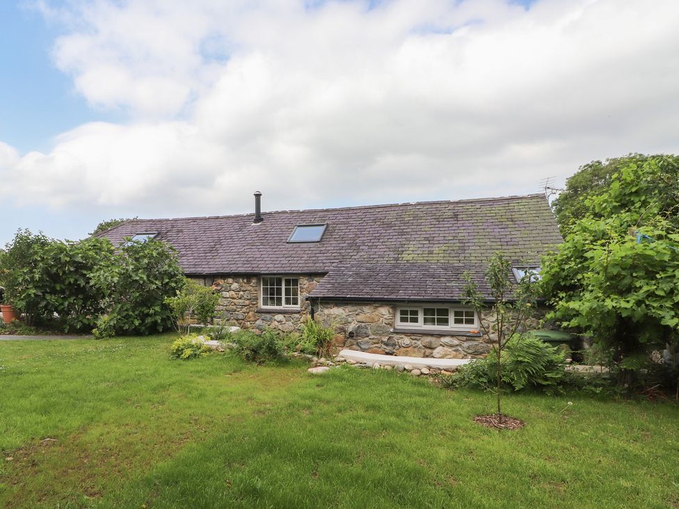 A cottage with garden and trees at Beudy'r Wennol in Groeslon