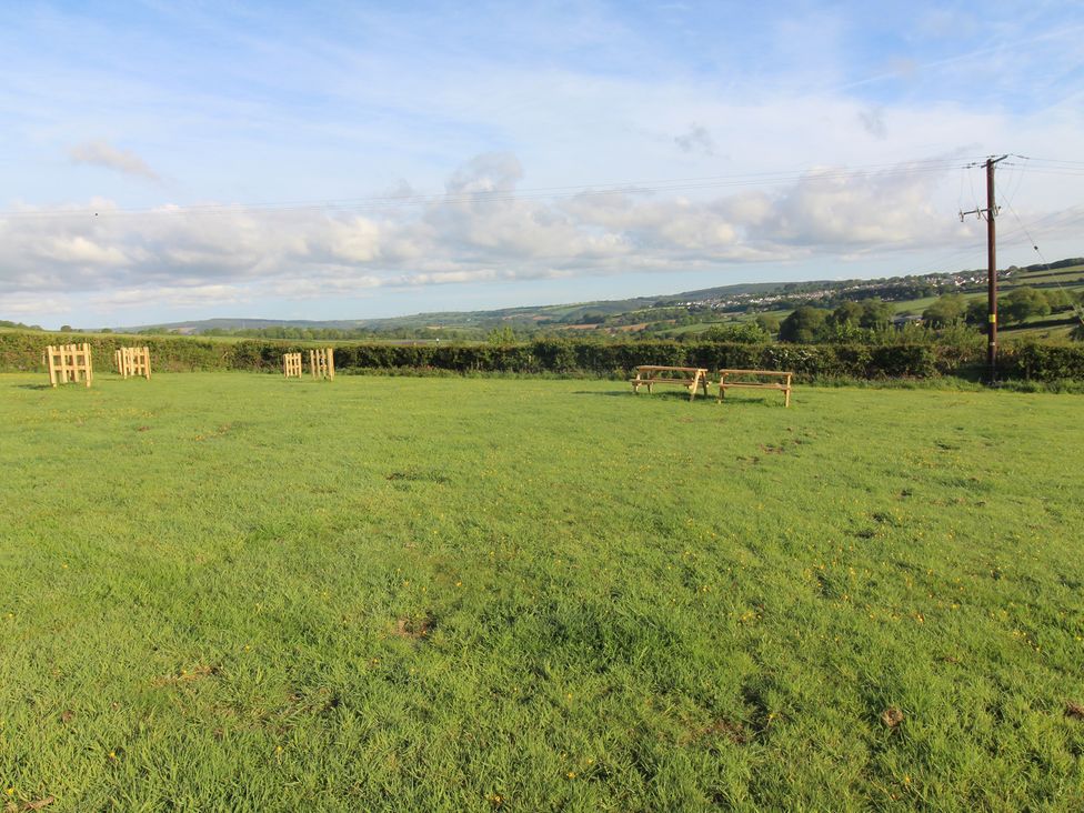 A grassy outdoor area with a viewing platform at Cedar Lodge in Lanivet near Bodmin