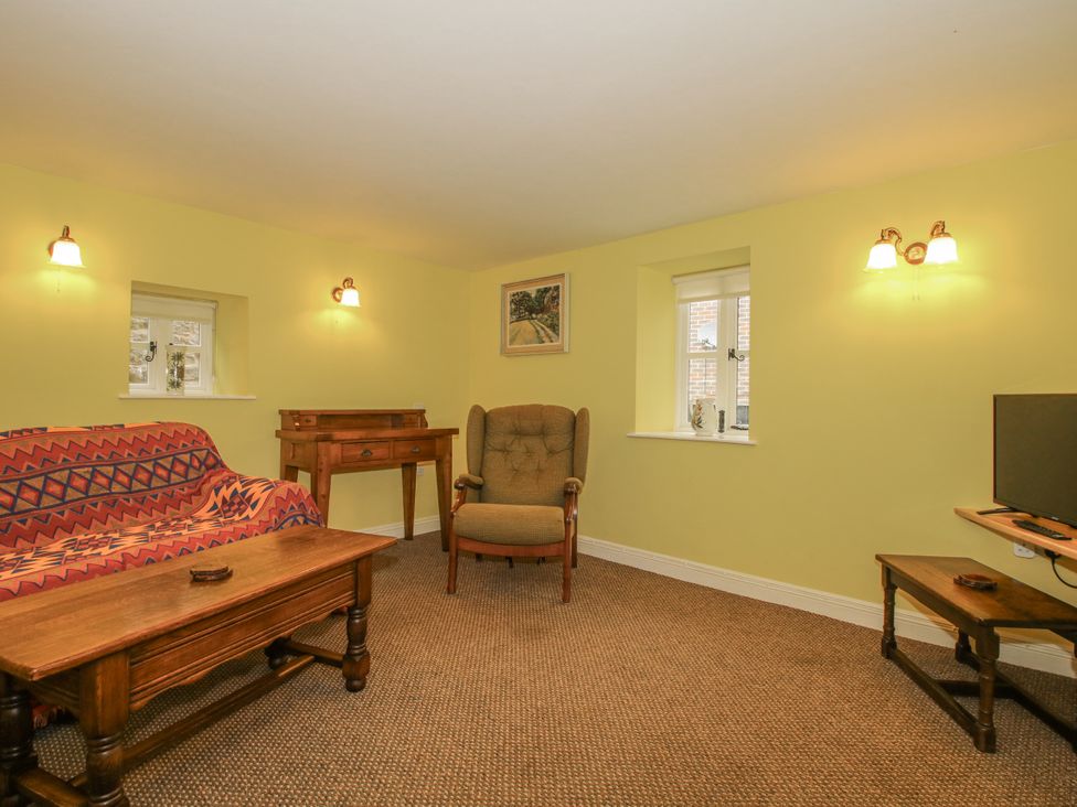 A living room with a sofa and table at Wash House Cottage in Much Wenlock