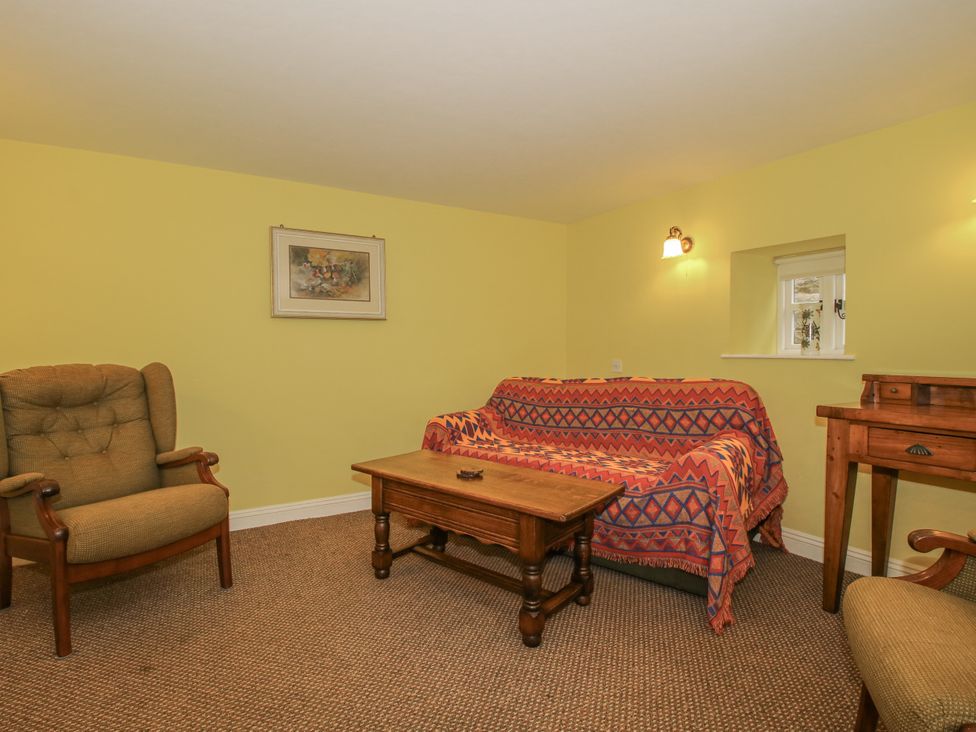 A living room with a sofa and armchair at Wash House Cottage Much Wenlock