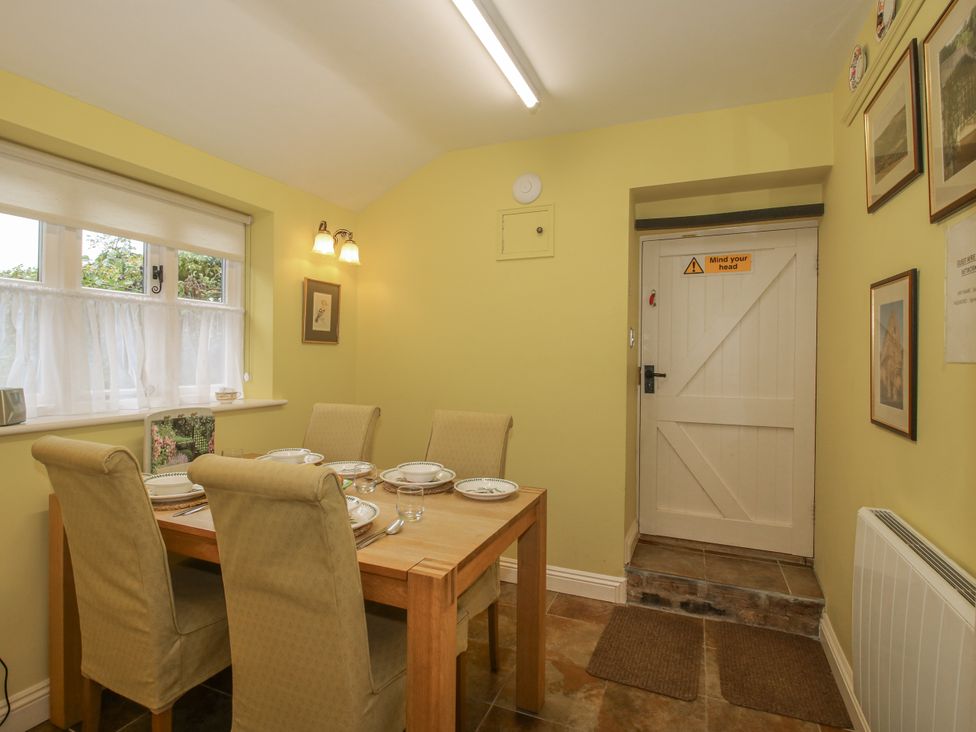 A dining room with a table and chairs at Wash House Cottage in Much Wenlock
