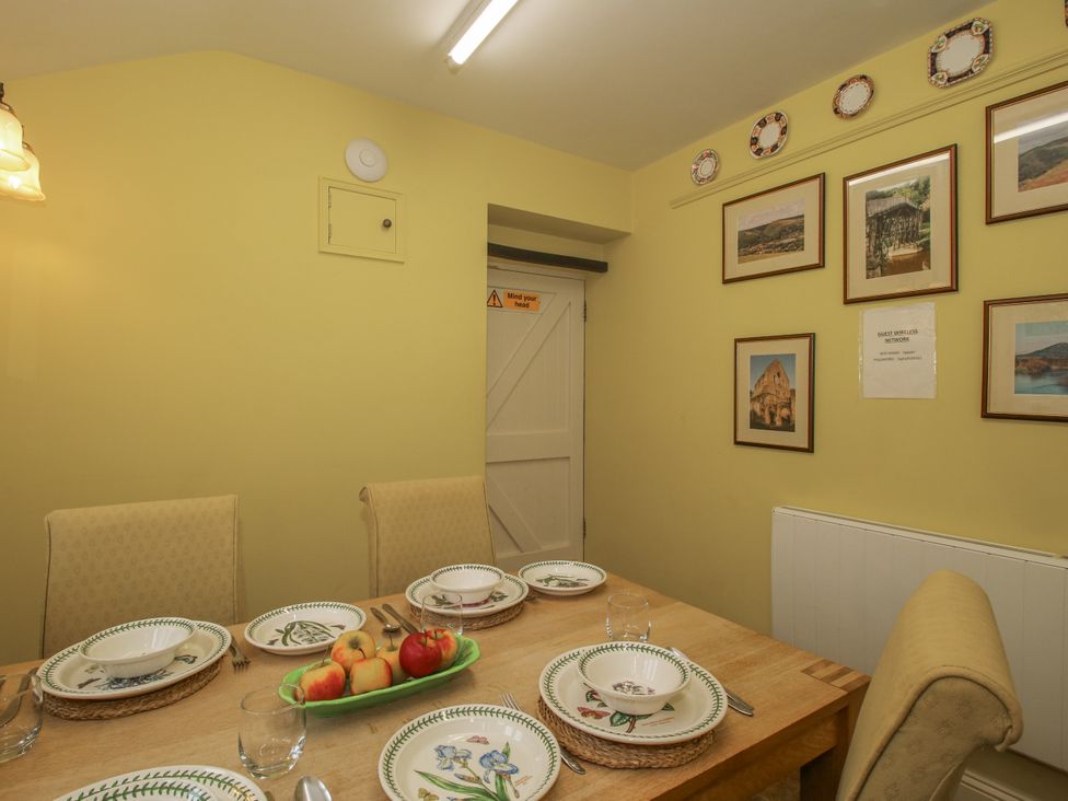 A dining room with a table set for meals at Wash House Cottage in Much Wenlock