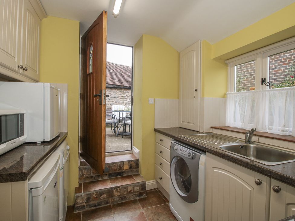 A kitchen with a door leading outdoors at Wash House Cottage in Much Wenlock