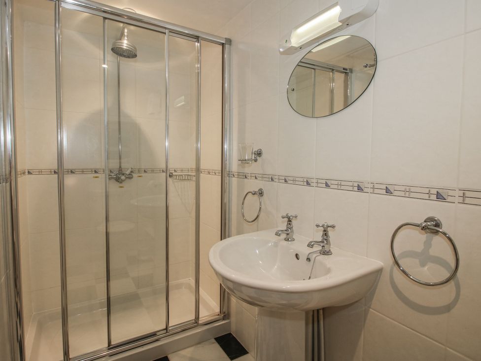 A bathroom with a shower and sink at Wash House Cottage in Much Wenlock