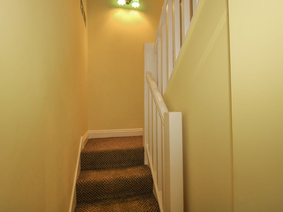 A staircase with carpet and light fixture at Wash House Cottage Much Wenlock