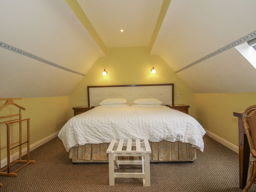 A bedroom with a bed and nightstand at Wash House Cottage Much Wenlock