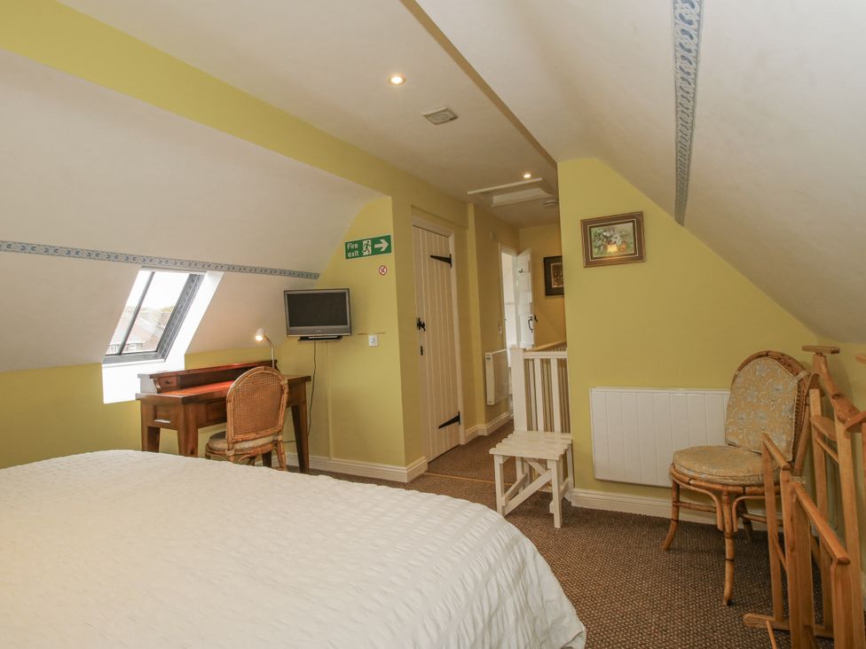 A bedroom with a desk and television at Wash House Cottage Much Wenlock