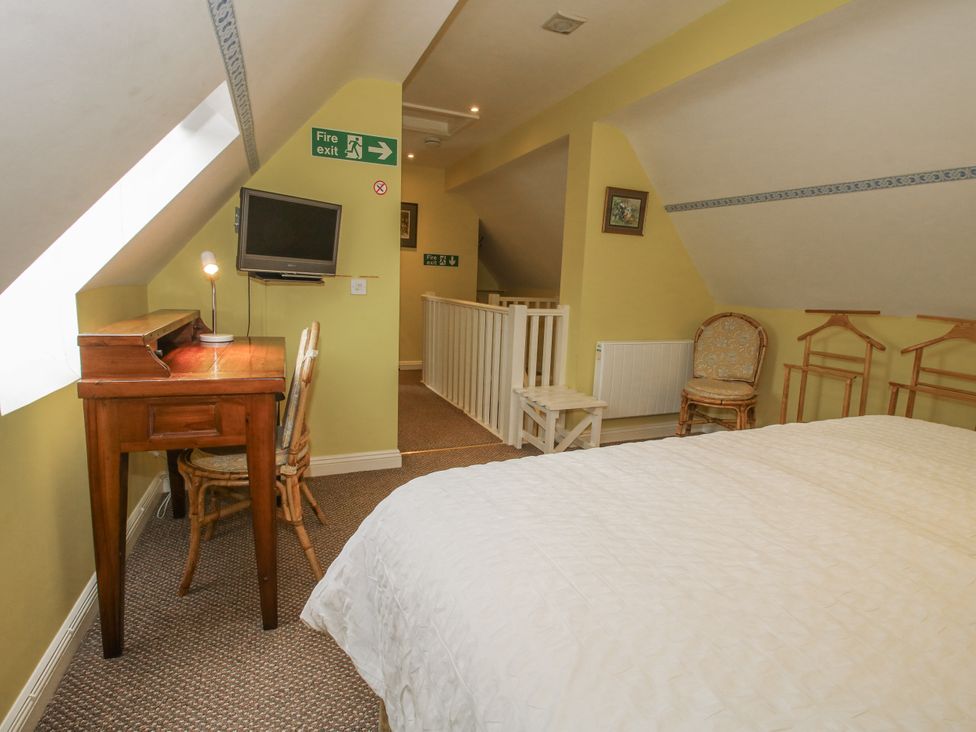 A bedroom with a desk and television at Wash House Cottage in Much Wenlock