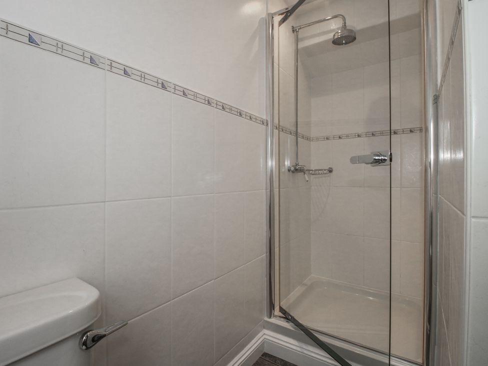A bathroom with a shower and toilet at Wash House Cottage in Much Wenlock