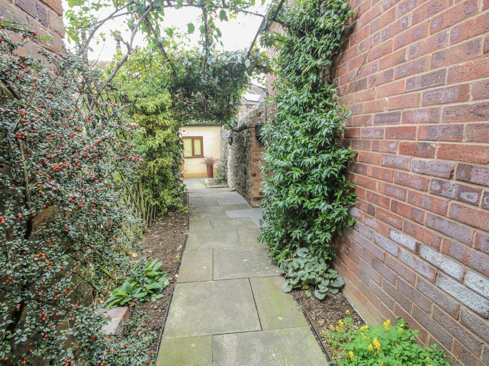 A pathway with plants and bushes in a garden at Wash House Cottage Much Wenlock