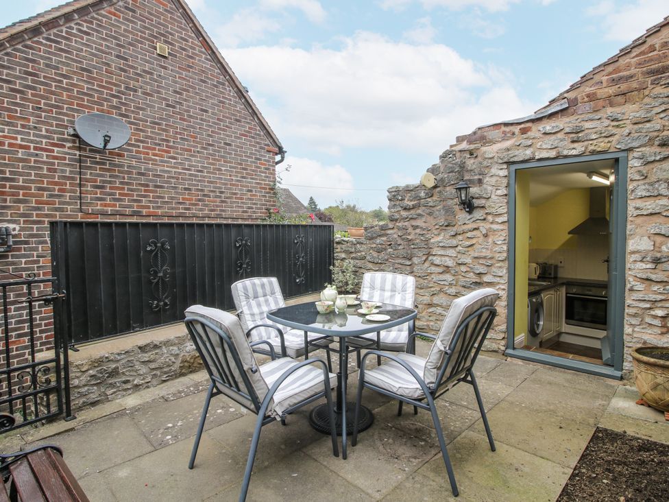 An outdoor area with a table and chairs at Wash House Cottage in Much Wenlock