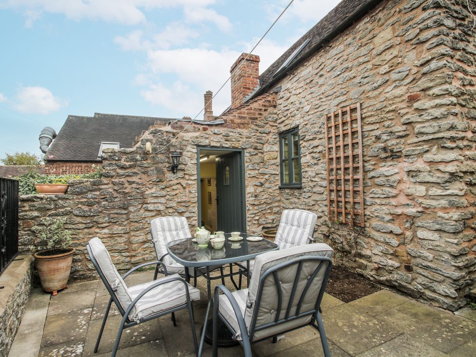 Outdoor seating area with a table and chairs at Wash House Cottage in Much Wenlock