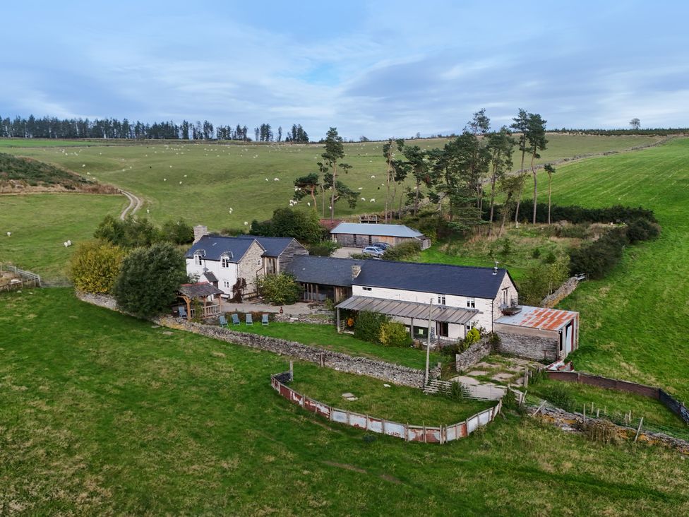 An outdoor view of a house and outbuildings with garden at Pant Dafydd Goch in Llangollen