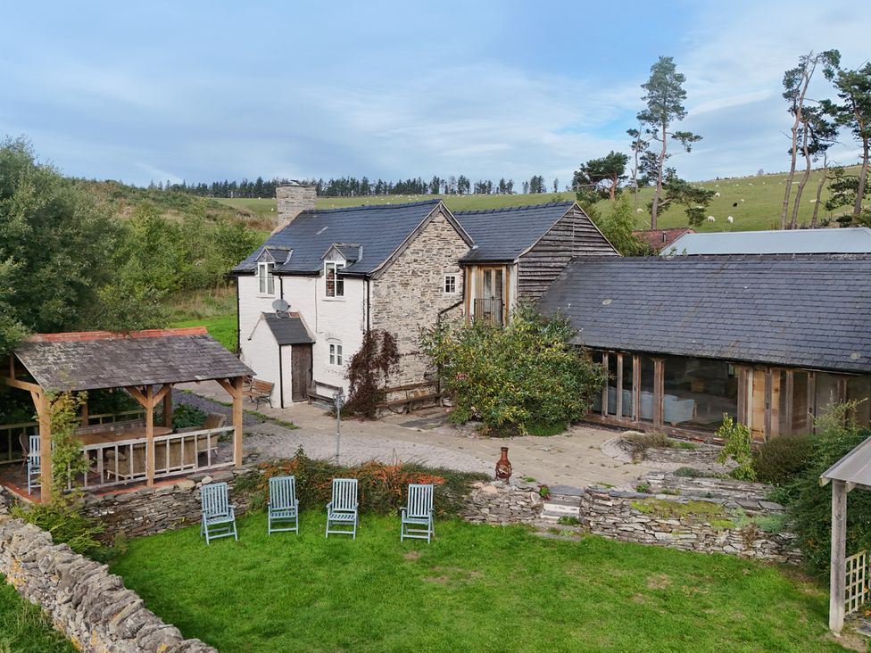 A garden with a house and outdoor seating at Pant Dafydd Goch in Llangollen