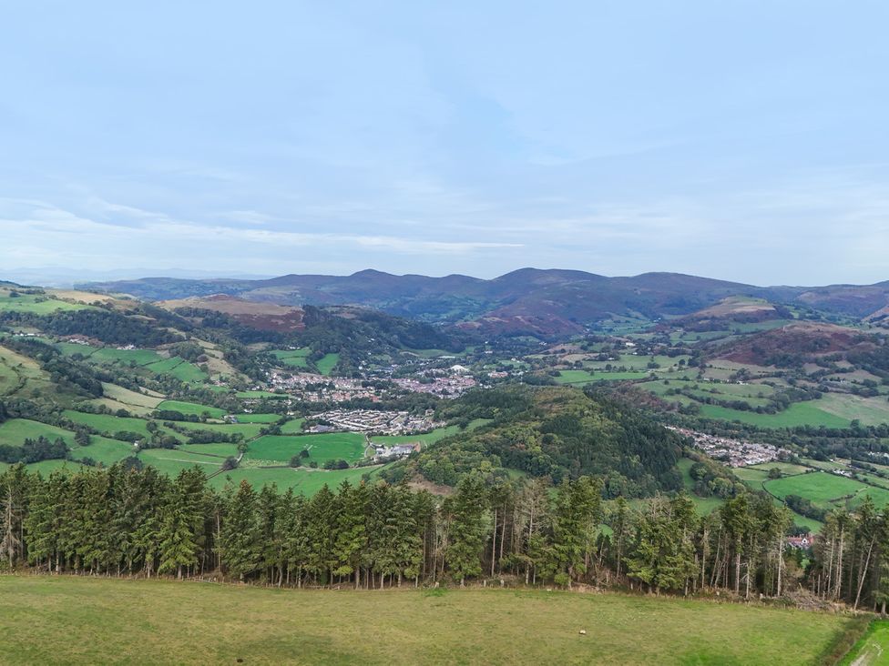 A view of a valley with mountains and a town at Pant Dafydd Goch in Llangollen