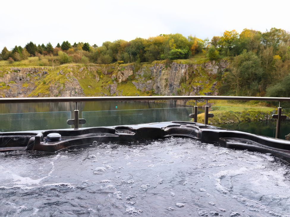 A hot tub with water overlooking a rocky cliff at Boavista in Carnforth